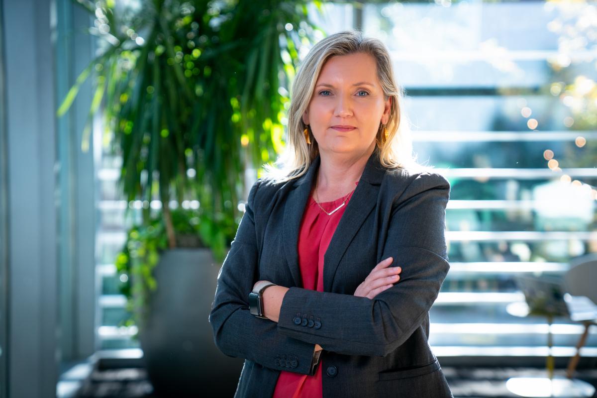 Woman in black suit and red shirt